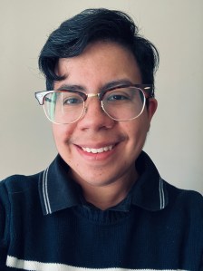 Photo of Loren Maria Guay, a smiling person with stylish short dark hair and glasses. 