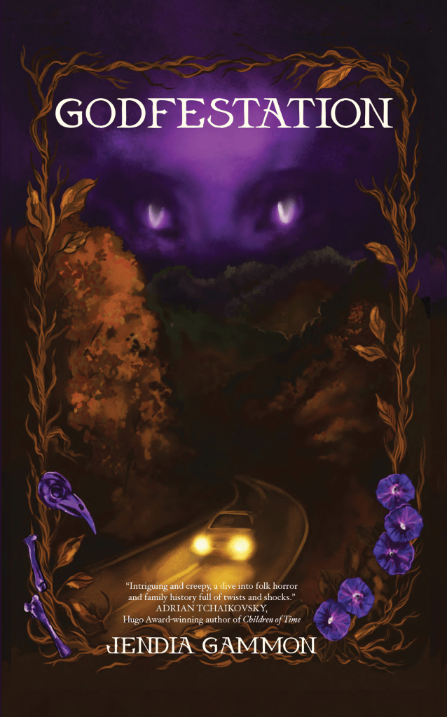 Cover art for the novella GODFESTATION written by Jendia Gammon, art by Danika Corrall. A late autumn bronze leaf and vine border frames the book, with a purple animal skull on the lower left, and purple morning glory blossoms on the lower right. Within the frame at the top, a large, strange purple face with oddly shaped eyes looms over a dark Southern Appalachian mountain range with a mountain road, down which a car drives with its headlights on.
Review quote:
“Intriguing and creepy, a dive into folk horror and family history full of twists and shocks.”
– Adrian Tchaikovsky, Hugo Award-winning author of Children of Time
